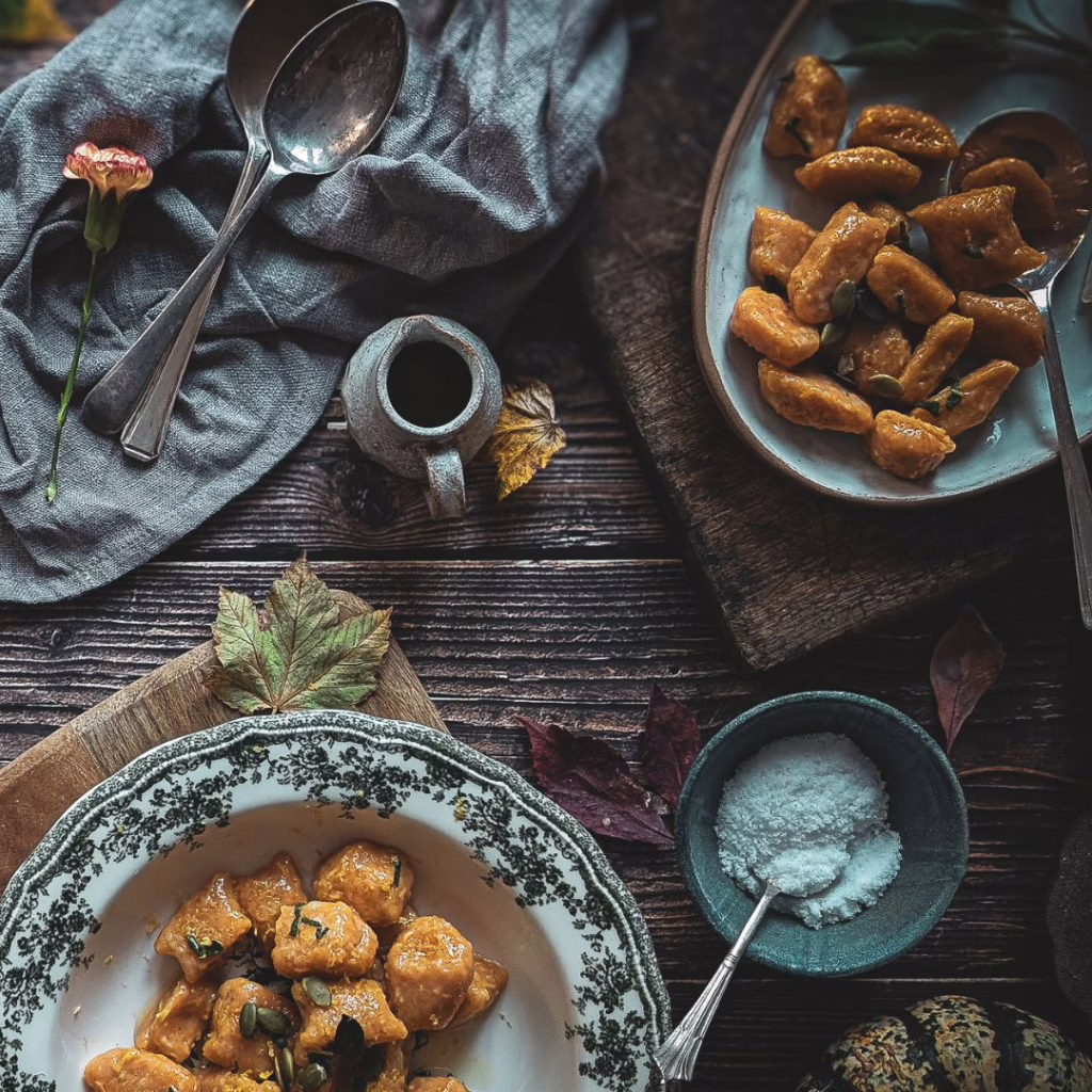 Pumpkin gnocchi with brown butter and crispy sage on a serving platter and on a bowl