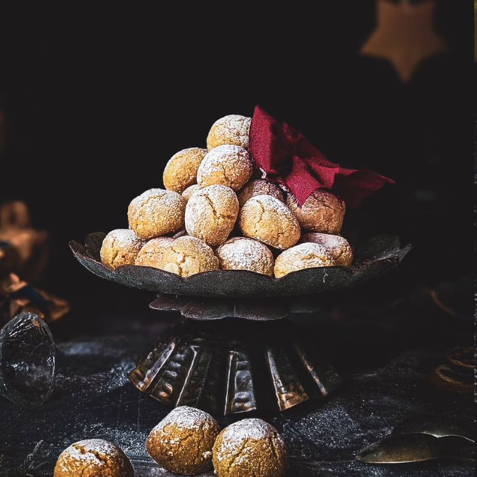 Soft amaretti piled up on a cake stand and decorated with a red ribbon