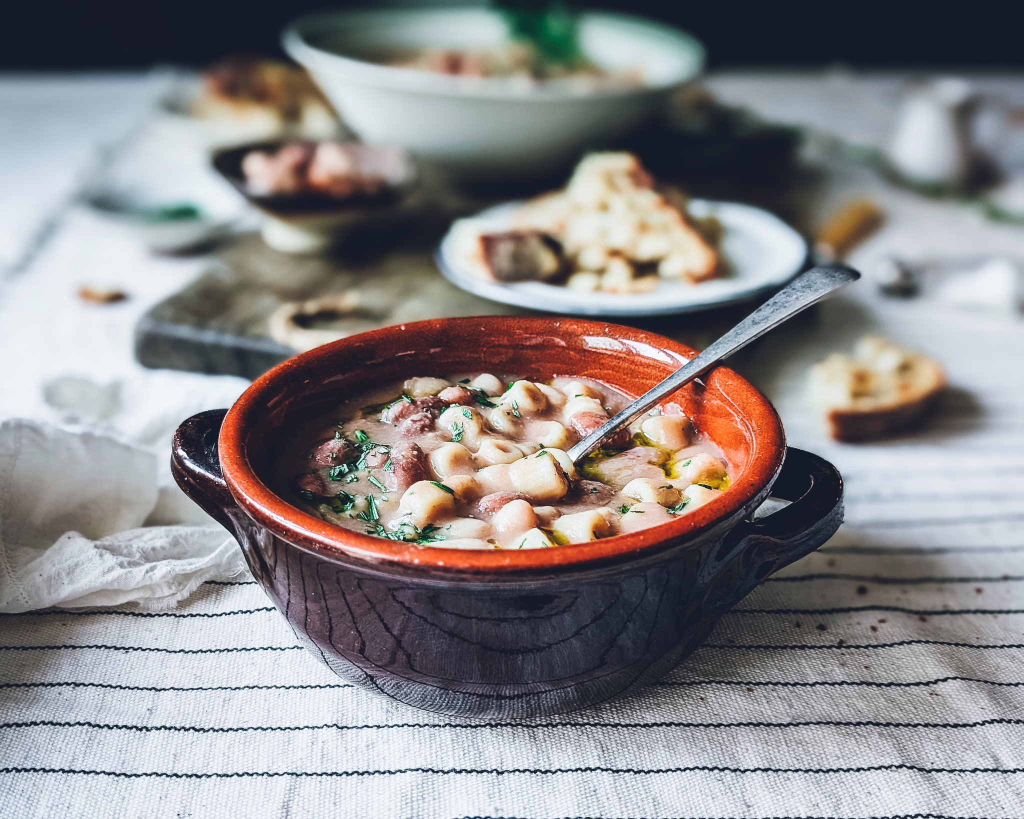 Rustic terracotta bowl filled with pasta e fagioli