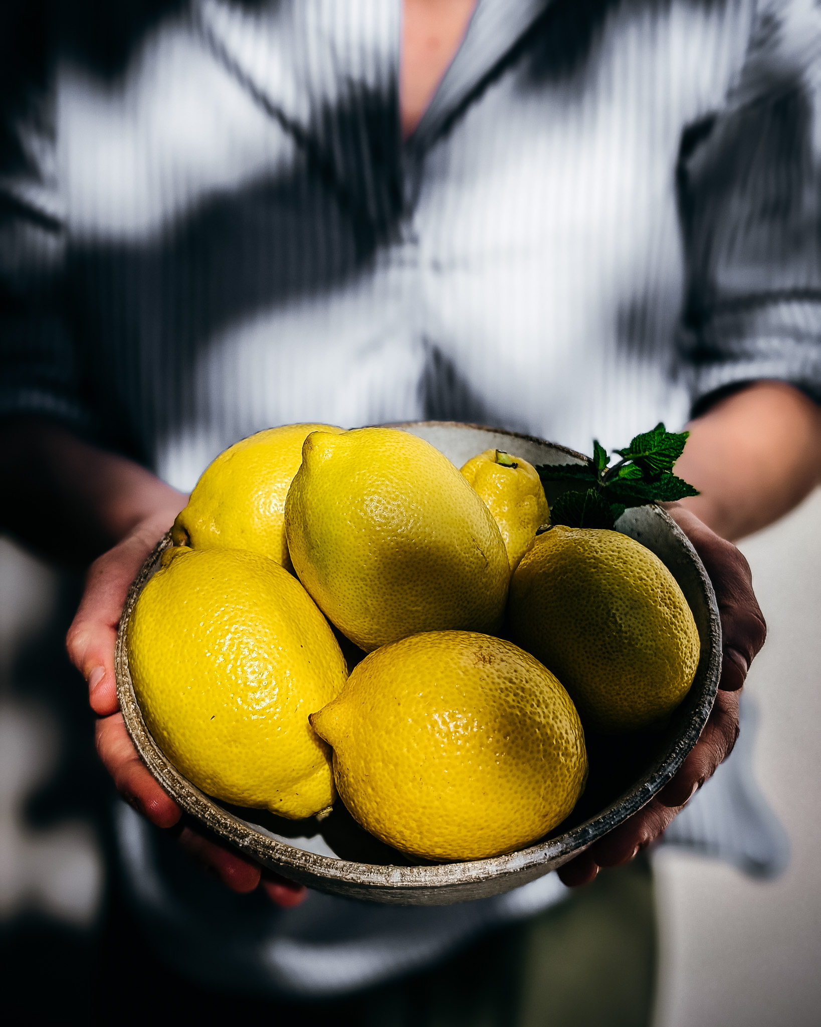 Woman holding bowl with lemons