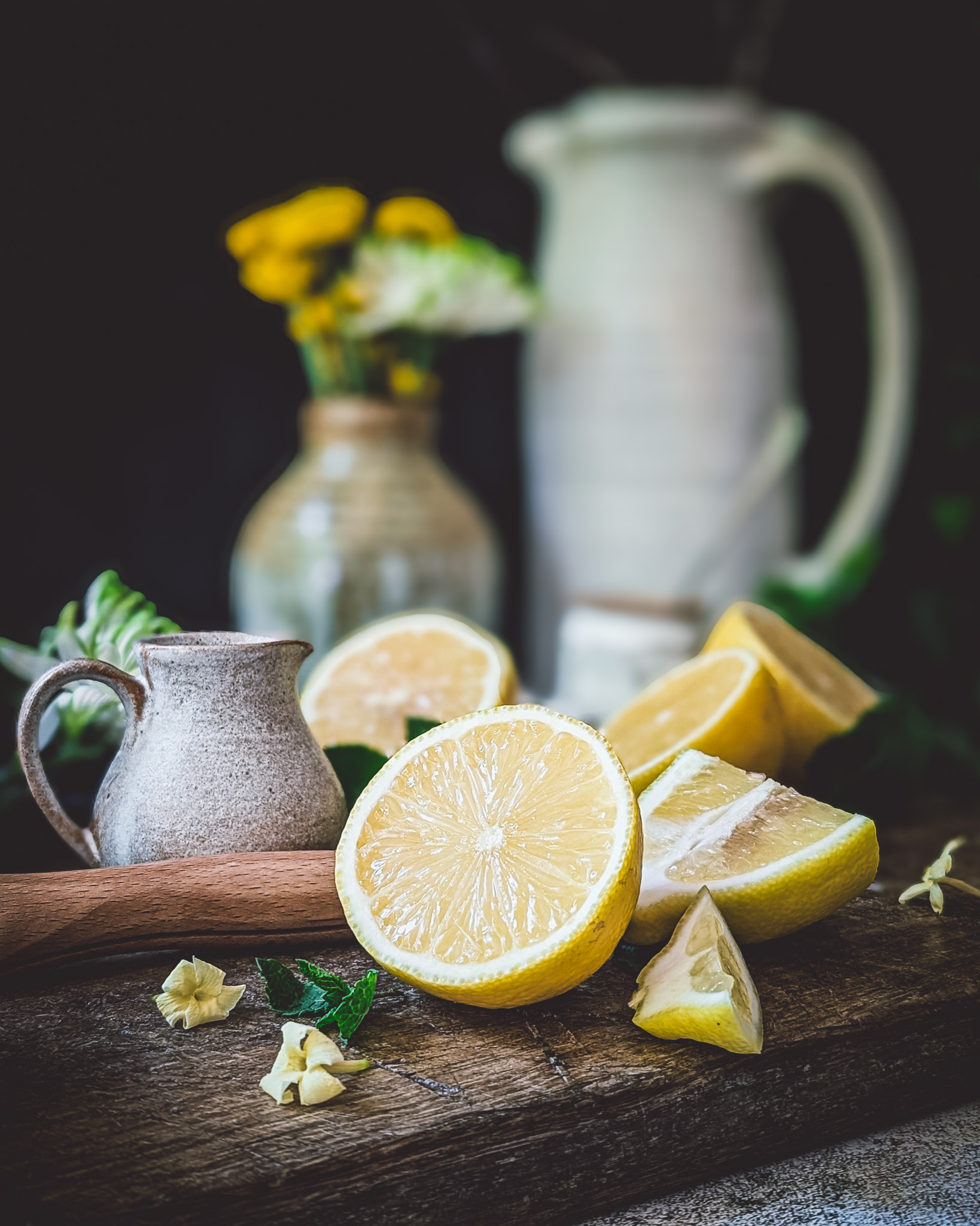 Lemons on a chopping board. On the background some ceramic vases.