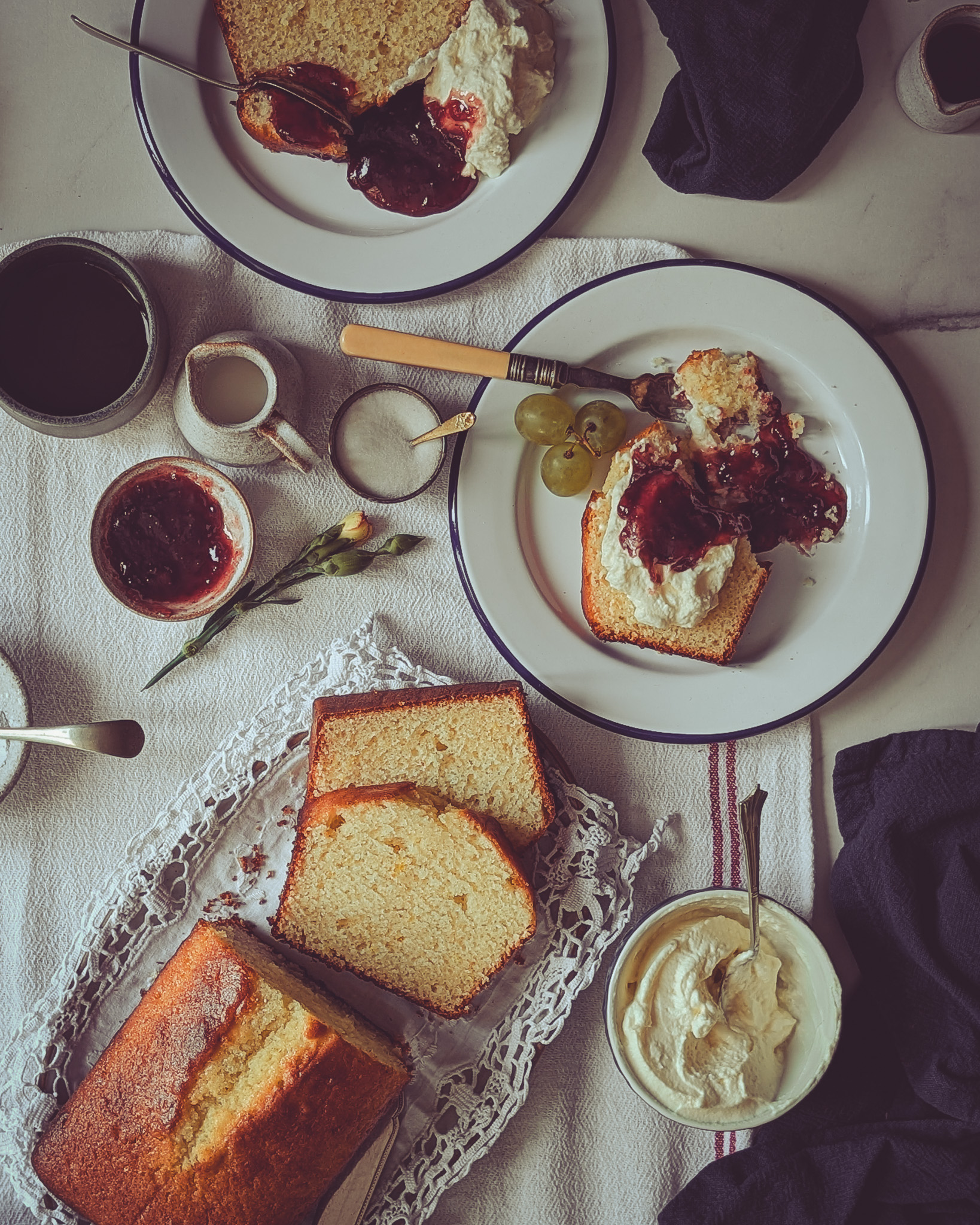 Two people eating Italian plumcake served with whipped cream and jam at a breakfast table.