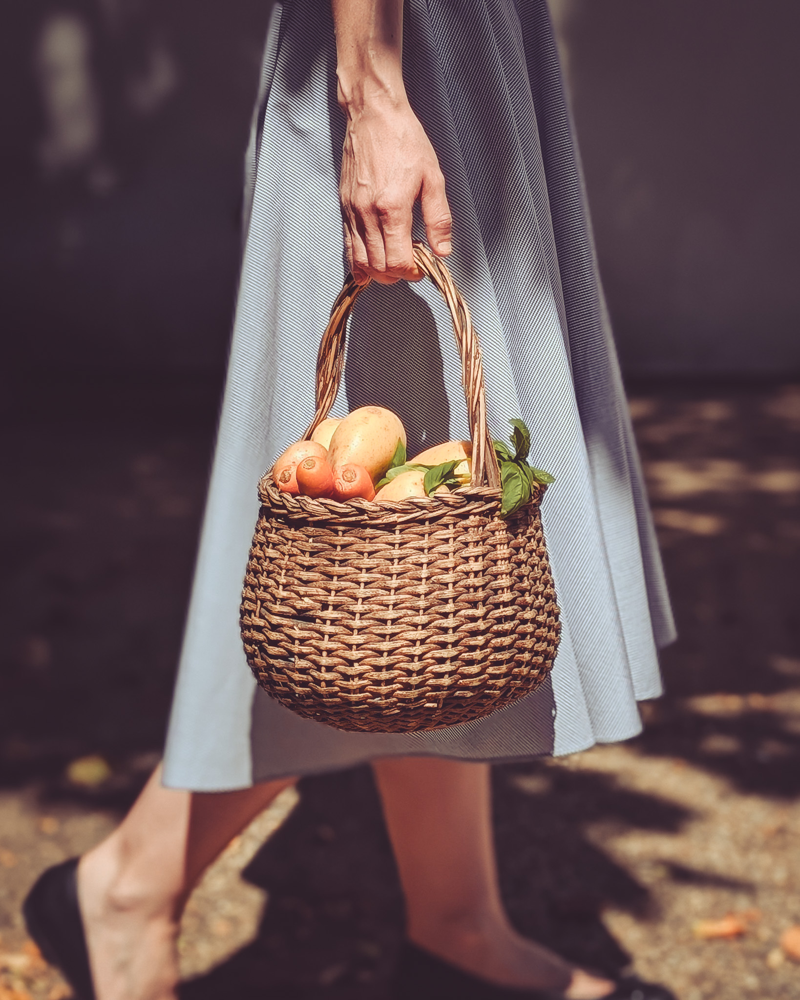 Woman carrying basket full of vegetables.
