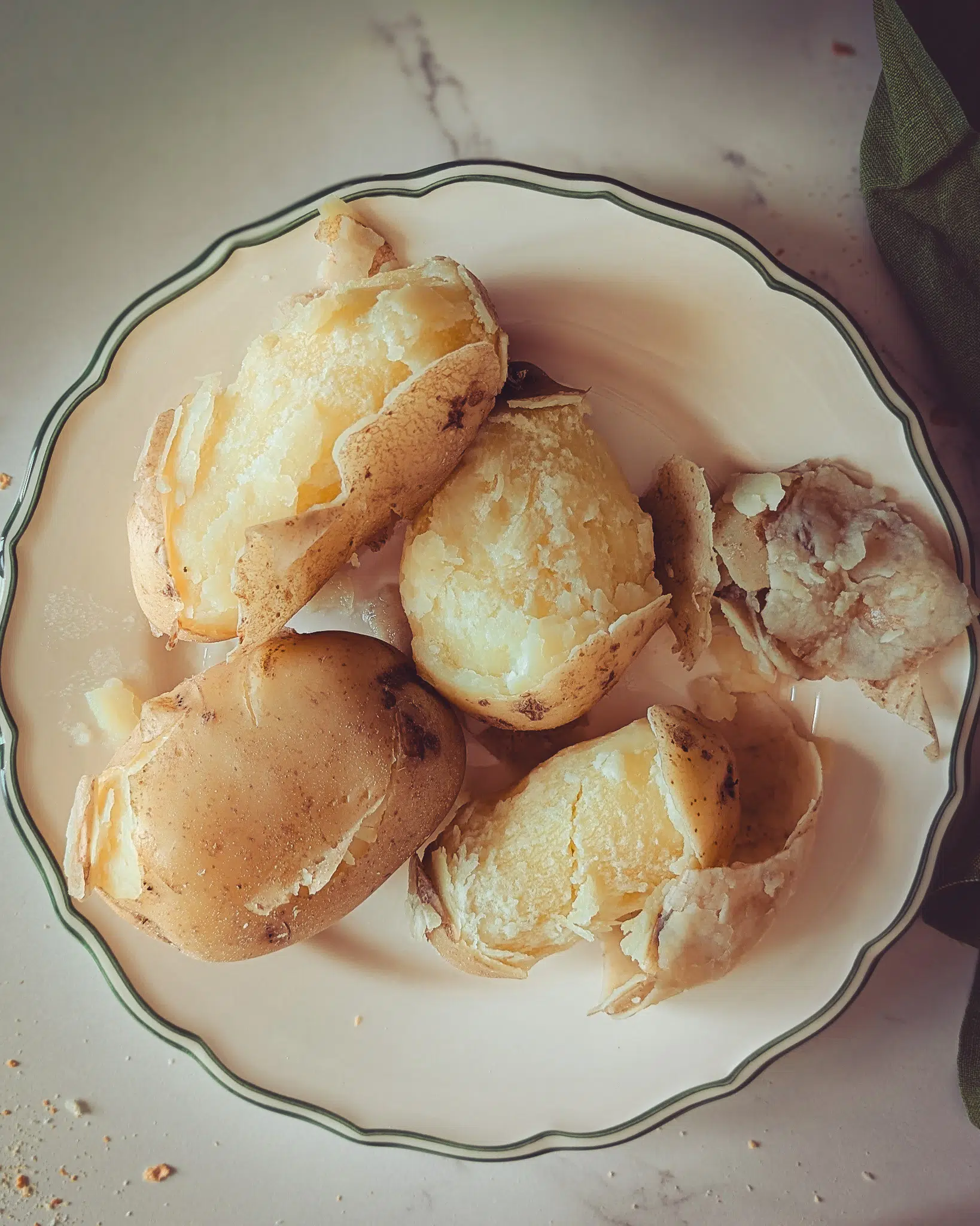 Close up of a plate full of boiled potatoes.