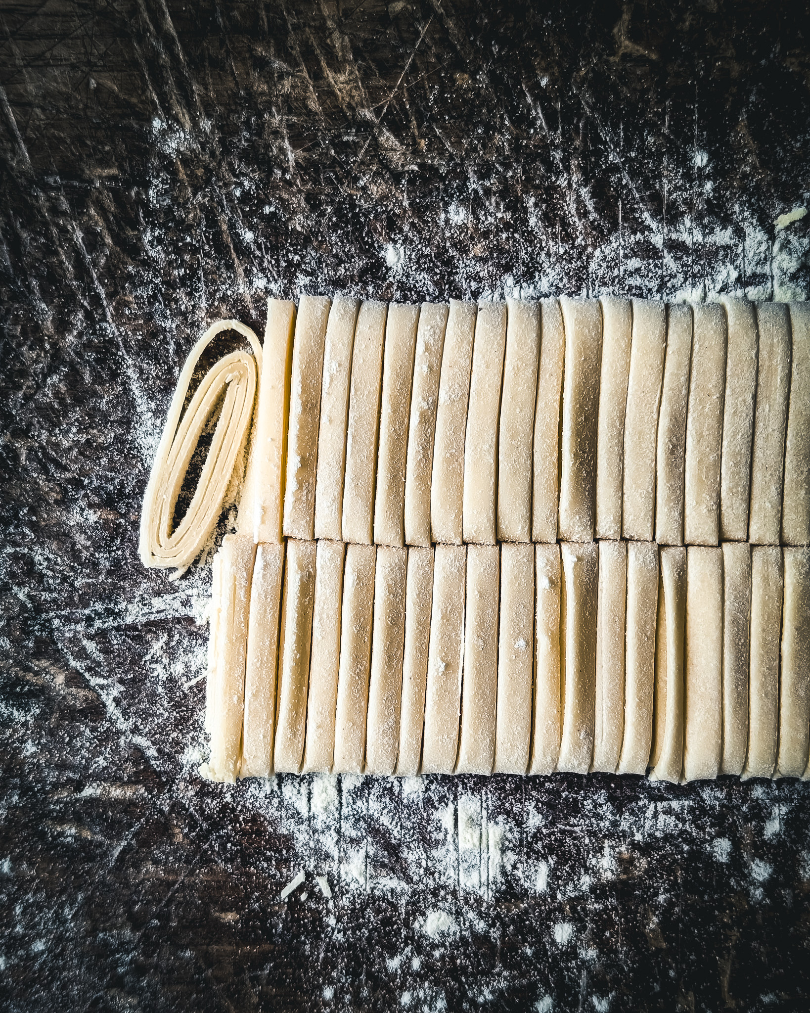 Fresh linguine on a wooden board.